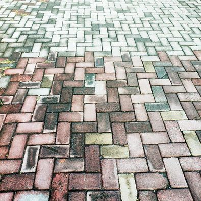 brick driveway that has been half pressure washed